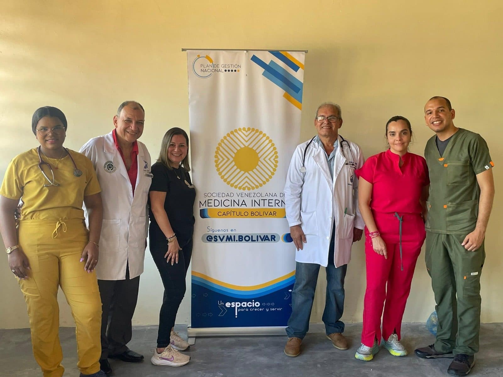 El Dr. Iván López con colegas junto al pendón de la Sociedad Venezolana de Medicina Interna, capítulo Bolívar